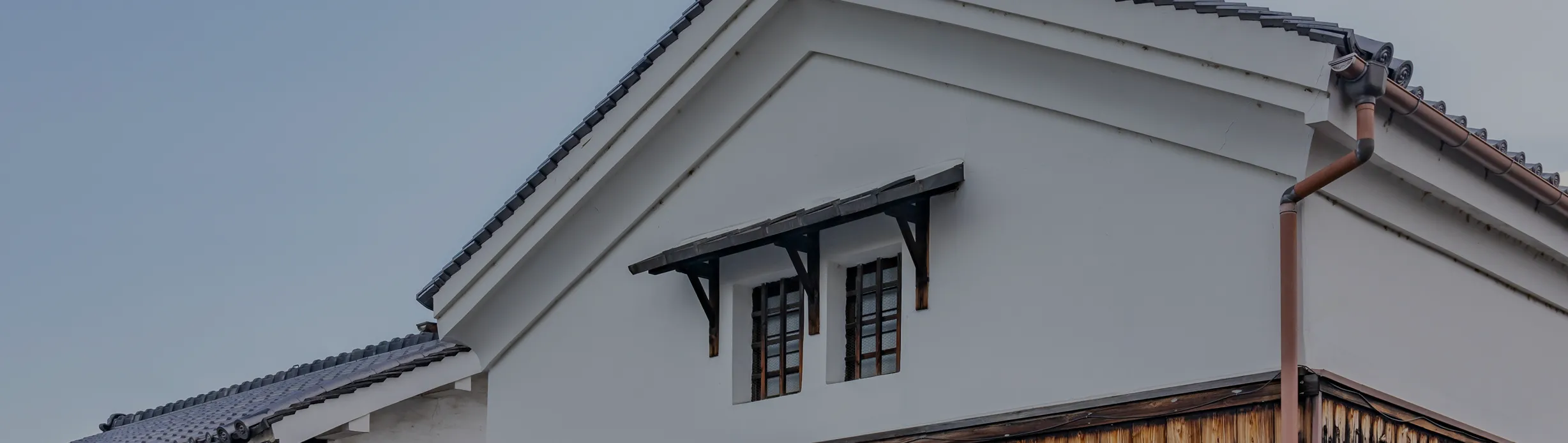 蔵の屋根を写したお問い合わせセクションの背景画像